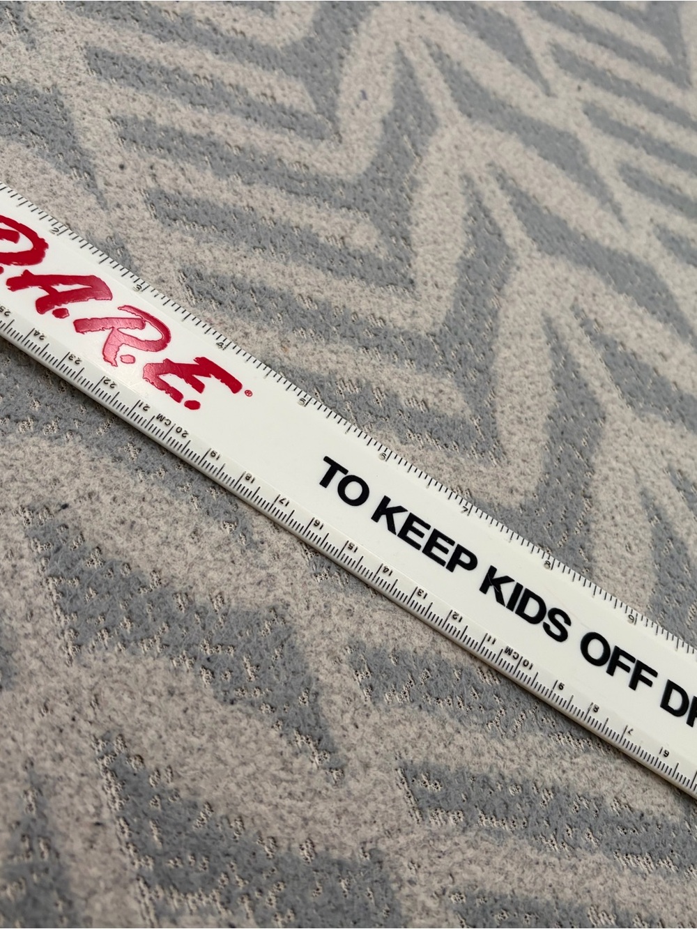 White Promotional Ruler with Red Logo and Black Text dare